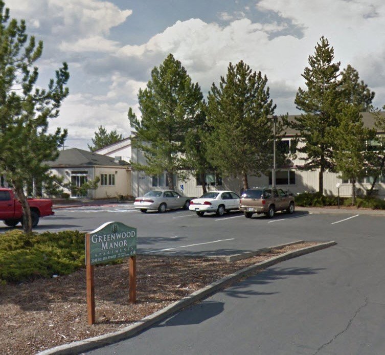 a parking lot with cars in front of a building